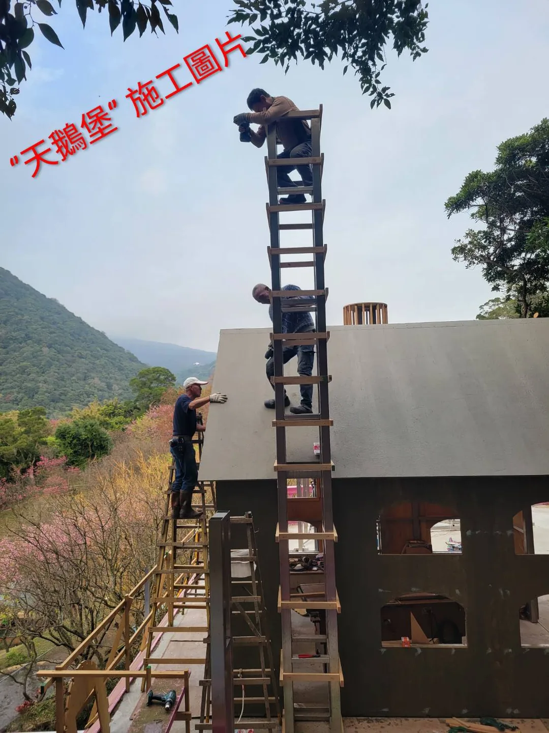 天鵝堡尖塔施工 天鵝堡施工現場:師傅站在數層樓高的鷹架上組裝尖塔骨架,背後是陽明山山景